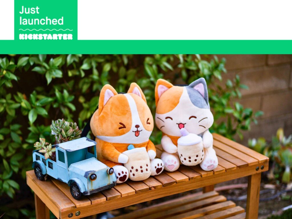 Plushy corgi and calico cat bags holding boba cups, sitting on a wooden bench next to a decorative blue truck planter with succulents